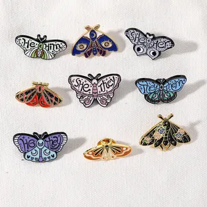 Set of artistic butterfly and moth enamel pins with pronoun text and floral patterns