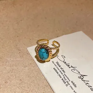 Detailed macro shot of a gold open ring with a turquoise stone and twisted rope border