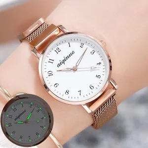 Detailed view of rose gold quartz watch with luminous hands and Milanese strap