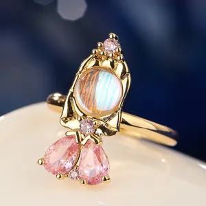 Macro view of fairy tale princess ring featuring iridescent moonstone and pink gemstones