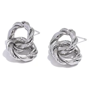 Detailed close-up of interlocking silver twisted hoop earrings with textured finish