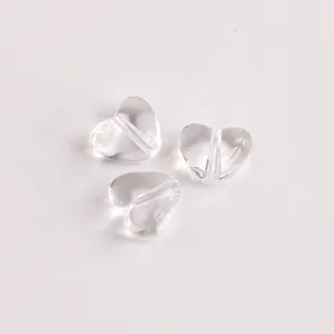Nahaufnahme von drei transparenten herzförmigen Acrylperlen für die DIY-Schmuckherstellung.