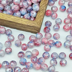Macro view of water-dyed marbled glass beads in red and blue tones for DIY jewelry.