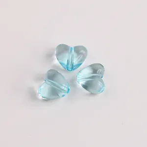Detaillierte Makroansicht von drei transparenten hellblauen herzförmigen Acrylperlen
