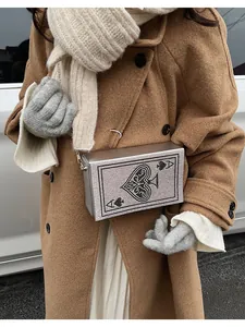 Sac bandoulière à strass argentés style carte à jouer porté avec un manteau d'hiver