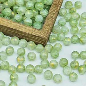 Macro detail of green glass beads with gold flecks for DIY jewelry making projects
