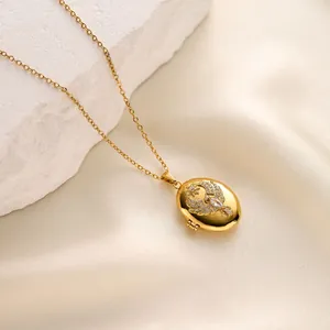 Detailed shot of a golden oval locket necklace featuring a micro-pave eagle pendant