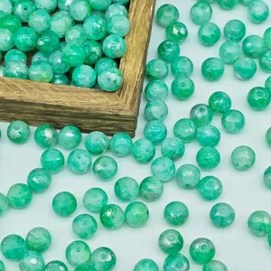 Detailed view of green water-dyed glass beads with elegant gold-splattered texture for DIY jewelry