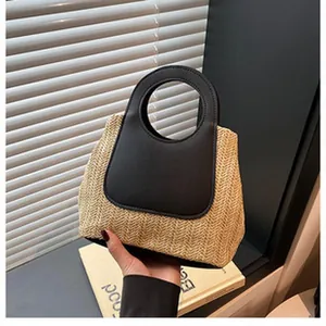 Woven straw handbag with black leather handle and chic minimalist design for summer