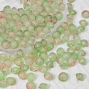 Detailed close-up view of 8x10mm green and red crackle glass saucer beads for DIY