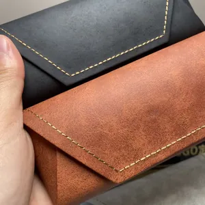 Gedetailleerde close-up van leertextuur op draagbare brillenkokers in zwart en tan kleuren.