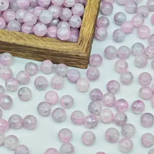 Macro detail of pink water-dyed glass beads with crackle texture for DIY jewelry.