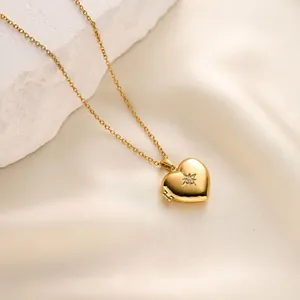 Detailed macro shot of a golden heart-shaped photo locket necklace on white silk fabric