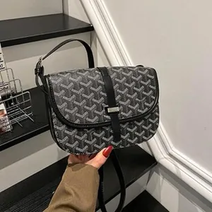 Close-up of classic geometric pattern on flip-cover shoulder bag