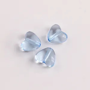Makro-Detail von drei hellblauen transparenten Acryl-Herzperlen für DIY-Schmuckhandwerk