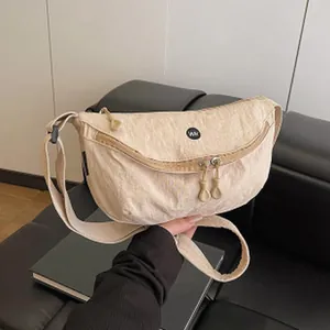 Macro view of a beige large capacity minimalist sling bag showing the textured fabric detail