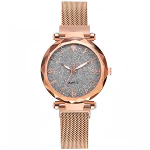 Macro view of women's rose gold quartz watch with glittery dial and Milanese mesh band.