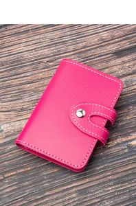 Dettaglio di un porta carte sottile in pelle rosa con chiusura a scatto e cuciture bianche