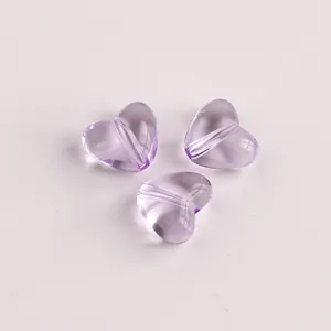 Nahaufnahme von drei fliederfarbenen, transparenten Herzperlen für DIY-Schmuck