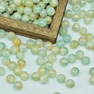 Close-up detail of 8mm green water-dyed glass beads with gold speckles for DIY jewelry