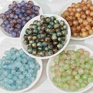 Close-up of multicolored 8x10mm lampwork glass beads displayed in small white plates