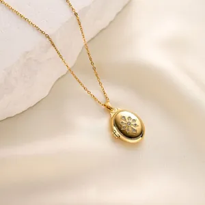 Close-up detail of a gold oval locket necklace featuring a micro-inlaid star pattern design