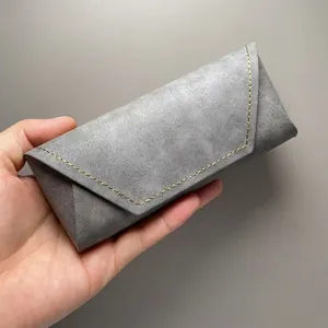 Grijze getextureerde PU-lederen brillenkoker met gouden stiksels
