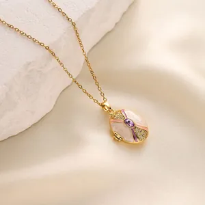 Close-up macro detail of a vintage gold enamel locket necklace with purple stone