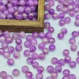 Macro view of purple marbled glass beads with gold foil accents for jewelry making