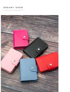 Assortimento di porta carte sottili in pelle con più scomparti in cinque colori su legno
