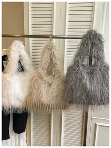 Detailed view of three solid color faux fur tote bags in white, beige, and grey.