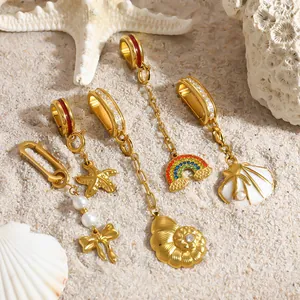 Close-up of gold-plated beach-themed charms including shells, rainbow, and starfish