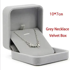 Detail of a gray velvet jewelry box showing a silver necklace inside, 10x7cm size.