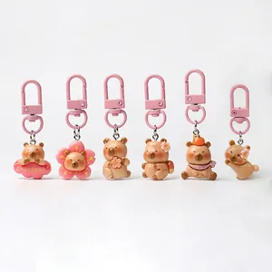 Detail view of six cute pink Capybara keychains in various adorable poses