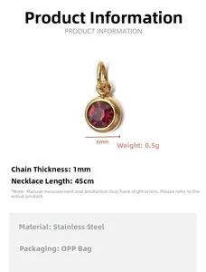 Macro view of a gold-tone stainless steel pendant featuring a red garnet birthstone crystal