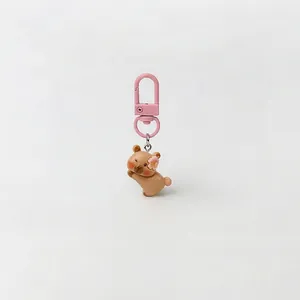 Detailed view of a cute capybara keychain with a pink flower and matching pink clip