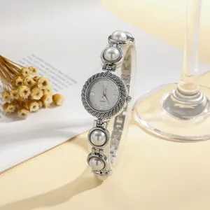 Elegant women's quartz watch with a decorative pearl bracelet strap detail