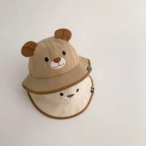 Detail of cute baby bucket hats with bear ears and embroidered faces for sun protection.