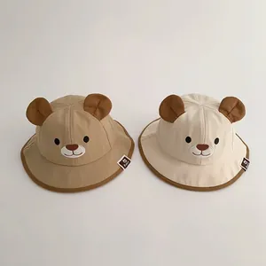 Detailed view of cute baby bucket hats featuring adorable bear ears in khaki and cream colors.