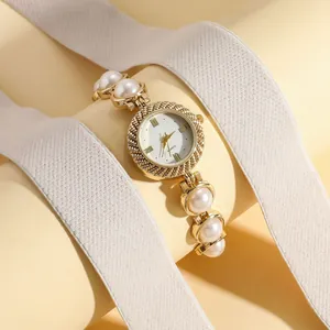 Detailed macro view of an elegant women's quartz watch featuring a pearl bracelet design