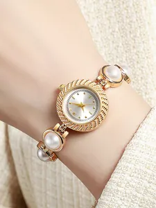 Gros plan d'une montre à quartz dorée élégante pour femme avec un bracelet en perles blanches