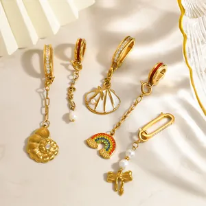Detail shot of gold-plated stainless steel charms with shell, rainbow and bow motifs