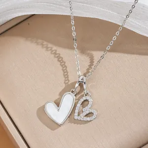 Primo piano della collana con doppio ciondolo a cuore e zirconi scintillanti