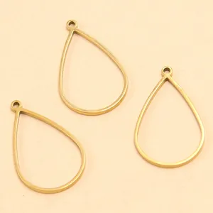 Gros plan de trois cadres de pendentif goutte en acier inoxydable doré pour bijoux DIY.