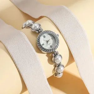 Close-up detail of a silver women's watch with a white pearl bracelet strap