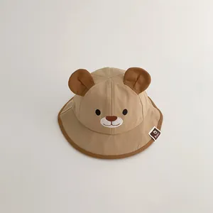 Detailed macro view of a cute khaki baby bucket hat featuring 3D bear ears and face embroidery