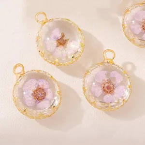 Detail shot of round glass pendants containing purple dried flowers for DIY jewelry making