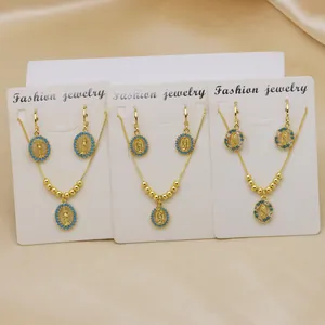 Detailed view of three Virgin Mary jewelry sets with turquoise beads and gold plating.