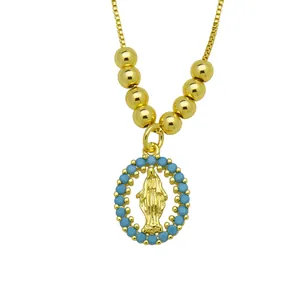 Macro view of religious Virgin Mary pendant necklace with gold finish and blue stones