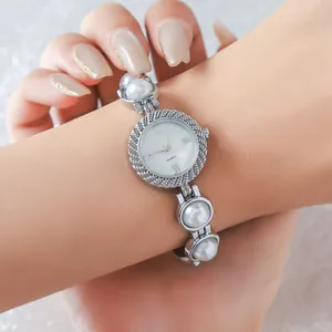 Close-up detail of silver ladies watch with elegant white pearl bracelet strap
